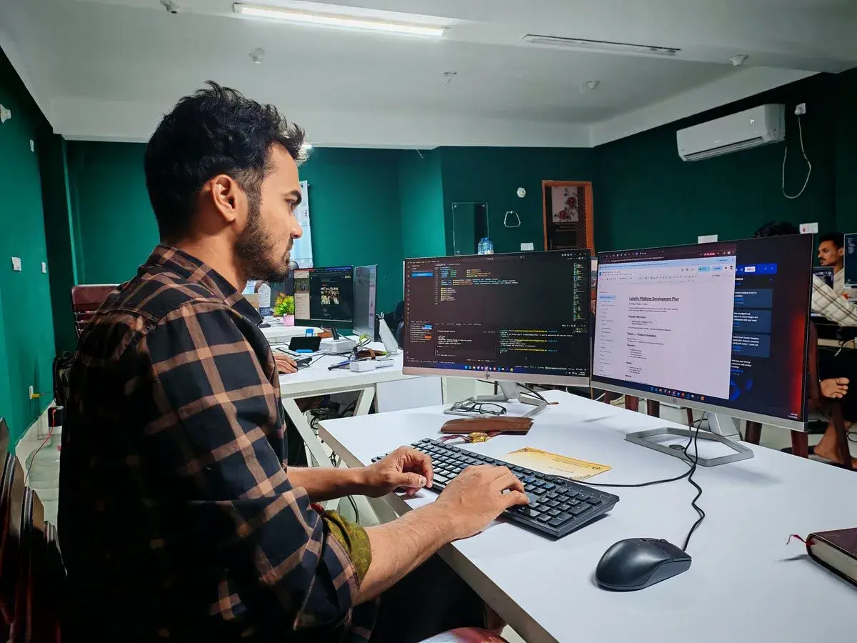 Desarrollador trabajando con dos monitores en una oficina moderna